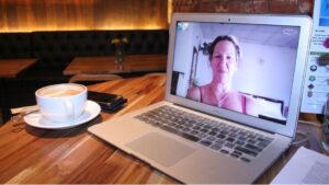 An open laptop with FaceTime opened up to a smiling woman