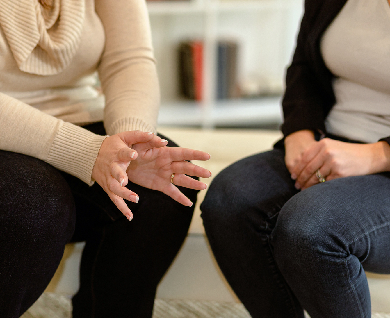 Close up of the hands of DBT Therapists Dr. Nikki Winchester and Dr. Desirae Allen as they talk.