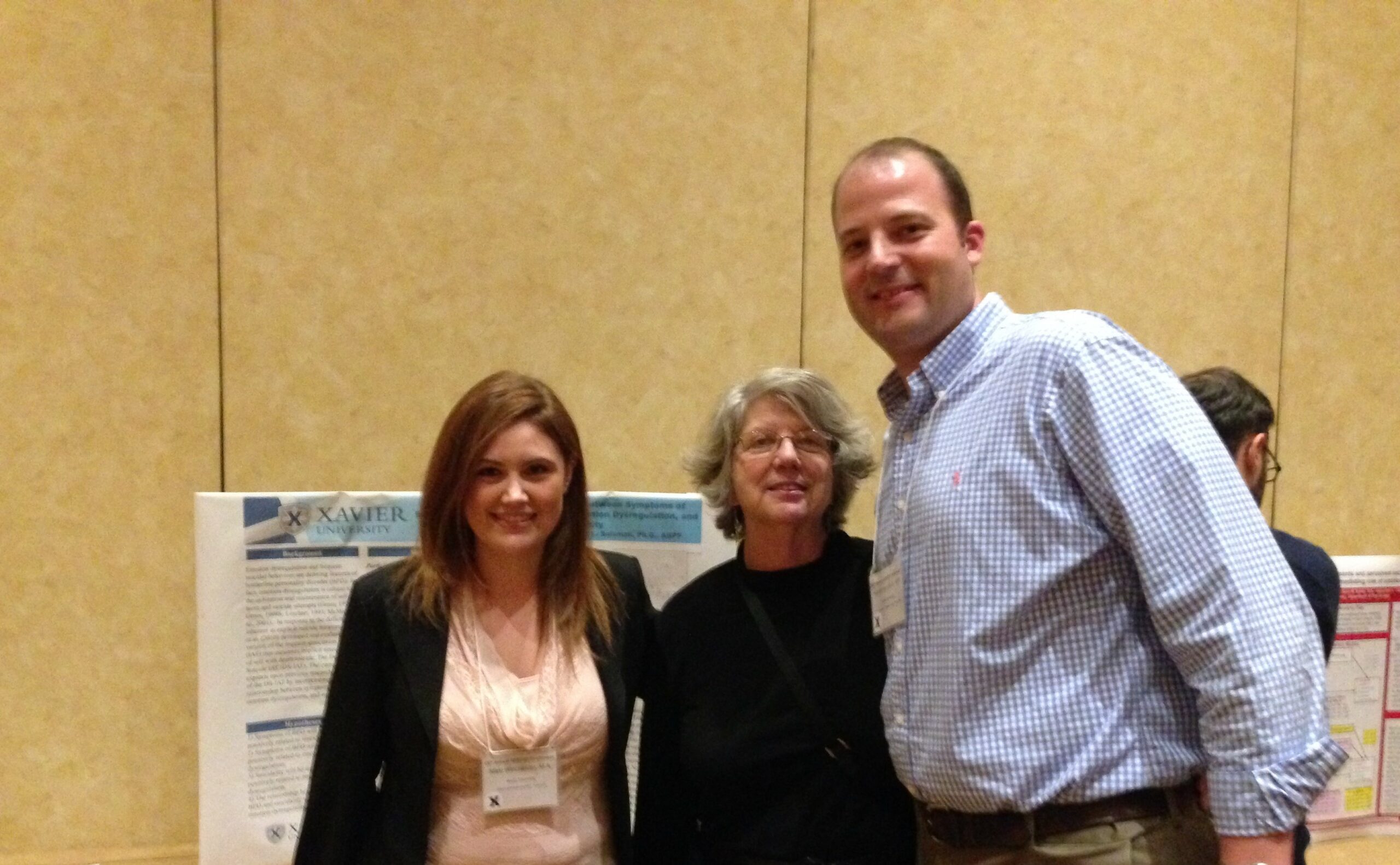 Nikki Winchester, Marsha Linehan (creator of DBT), and Nick Salsman in front of Nikki's DBT dissertation research