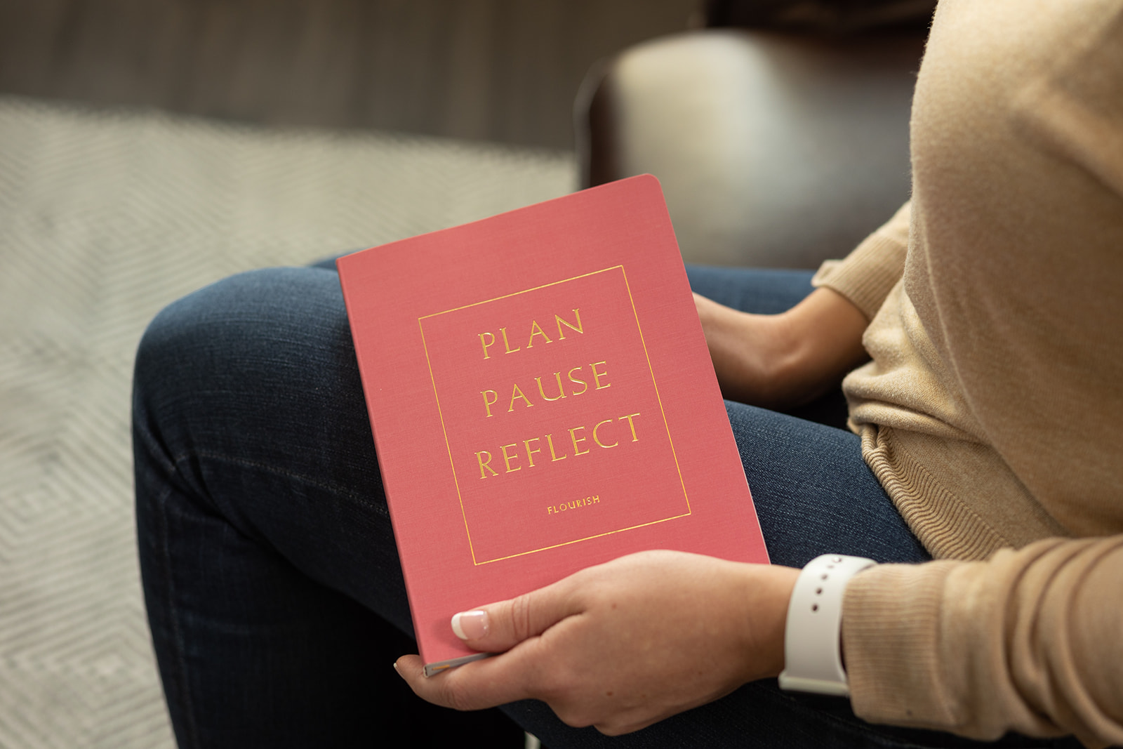 Pink journal that says, "Plan, pause, reflect" on the cover, held by DBT therapist Dr. Desirae Allen at Cincinnati Center for DBT. DBT skills are helpful in maintaining sobriety from alcohol and drugs.