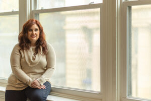 Dr. Nikki Winchester, DBT therapist at Cincinnati Center for DBT, sits on a windowsill considering myths about borderline personality disorder (BPD)