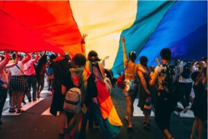 People standing outside under a rainbow parachute