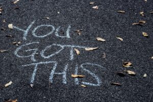 The words, "You got this" written in chalk on blacktop