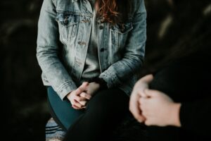 Girl sitting with legs crossed and hands folded