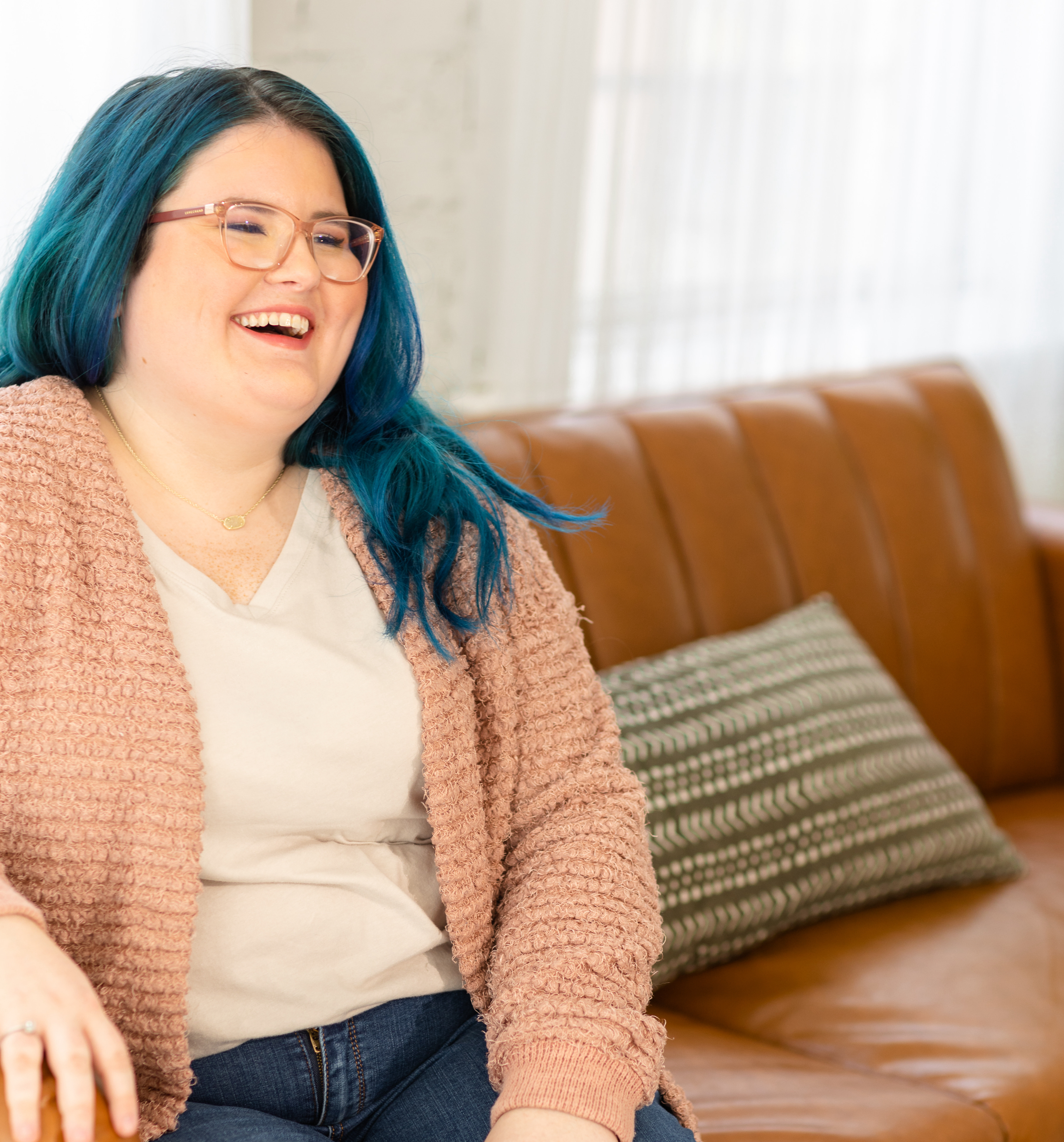 Jennifer Garner, DBT therapist at Cincinnati Center for DBT, sits on a couch and laughs at something off camera