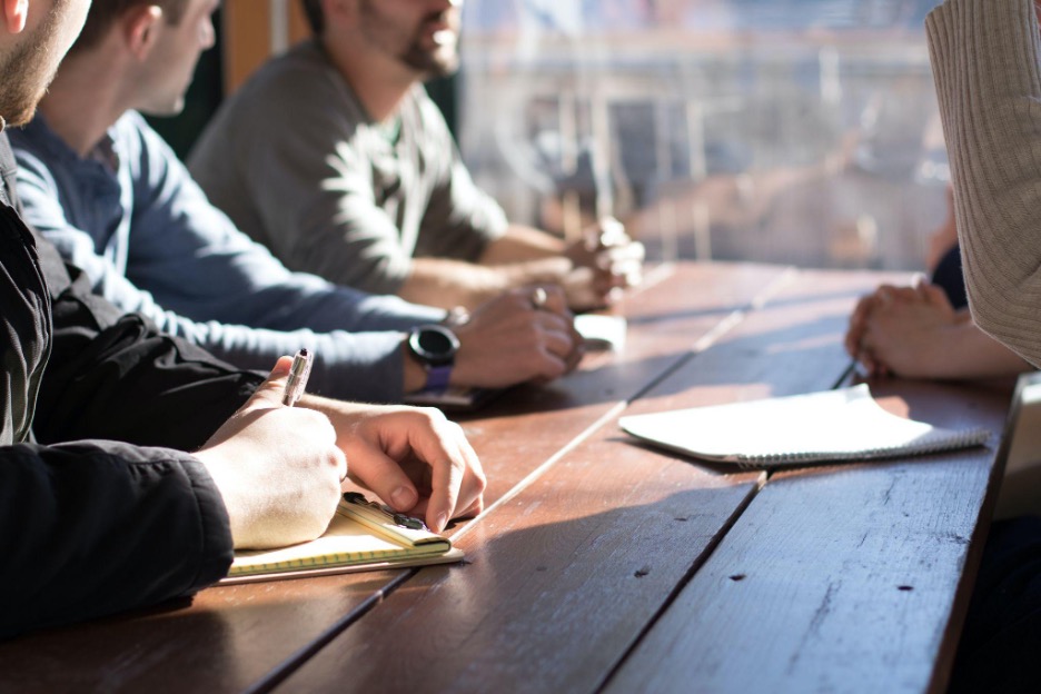 People gathered around a table with pens and papers