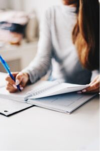 Girl sitting at desk writing in notebook