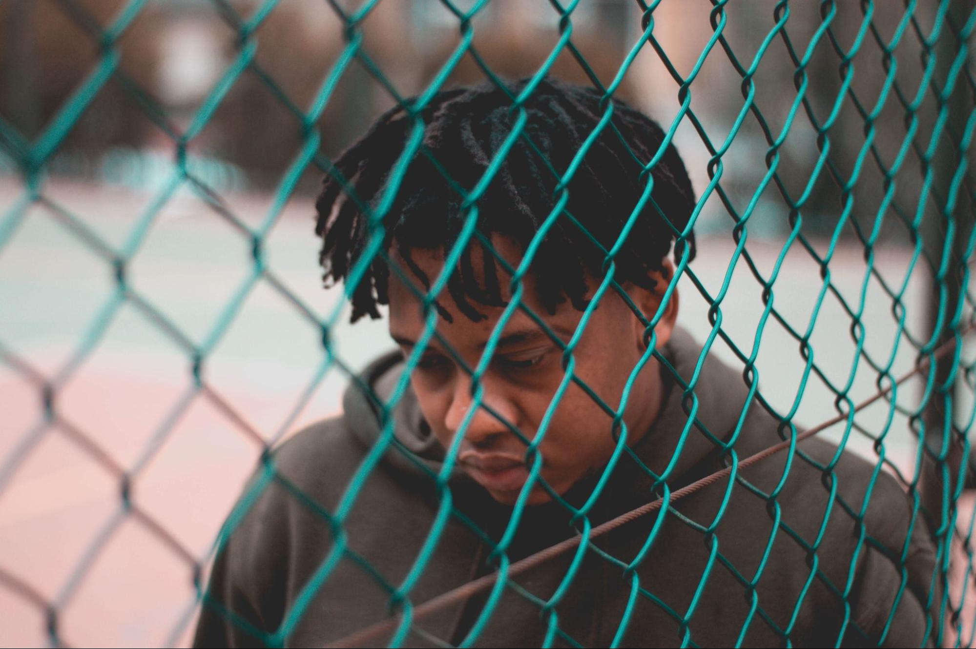 boy sad walking by fence