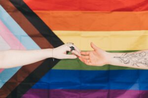 Support lgbtqia+ youth pride flag hands touching