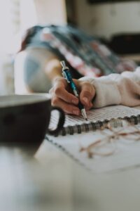 hand writing in book pen coffee or tea mug