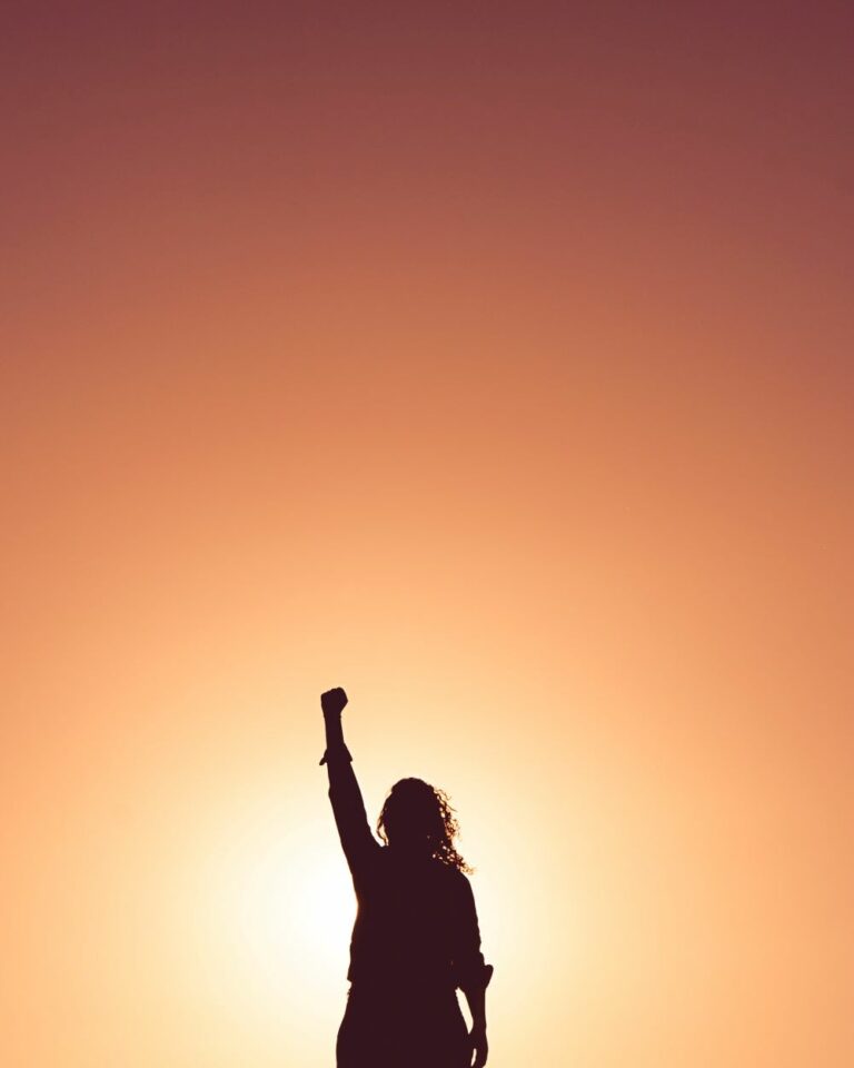 orange gradient hand empowered in fist pointing up