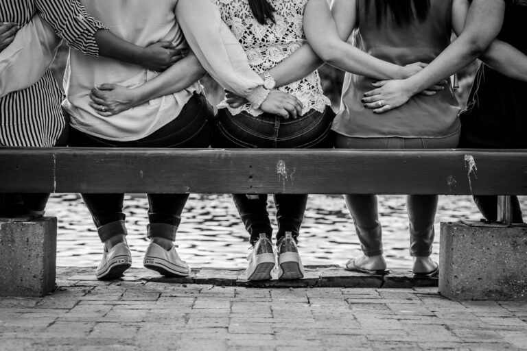 women sitting together on bench