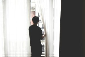 an individual looking out the window in solitude 