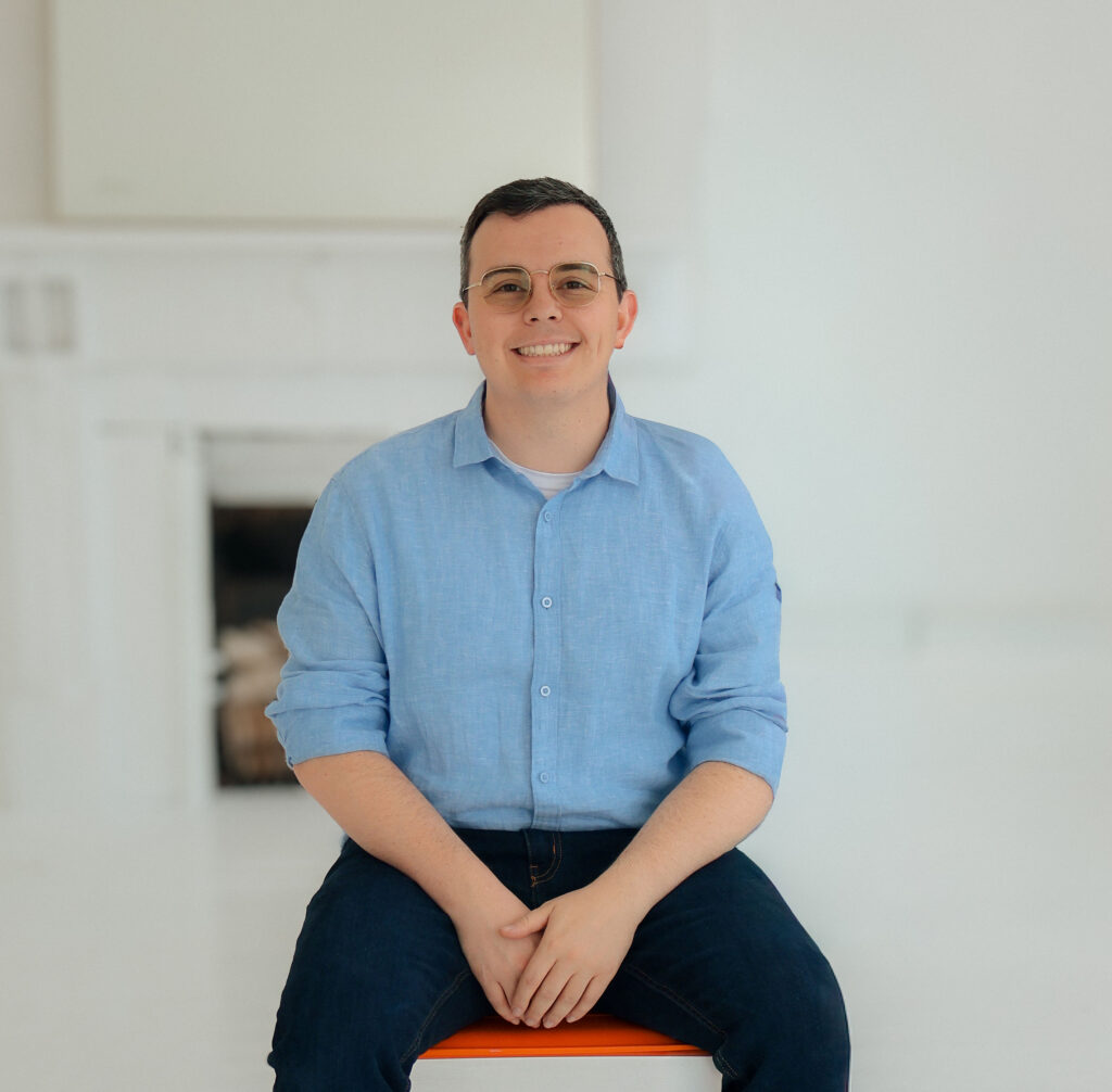Cincinnati DBT Therapist Jordan Binder sits on a chair smiling at the camera