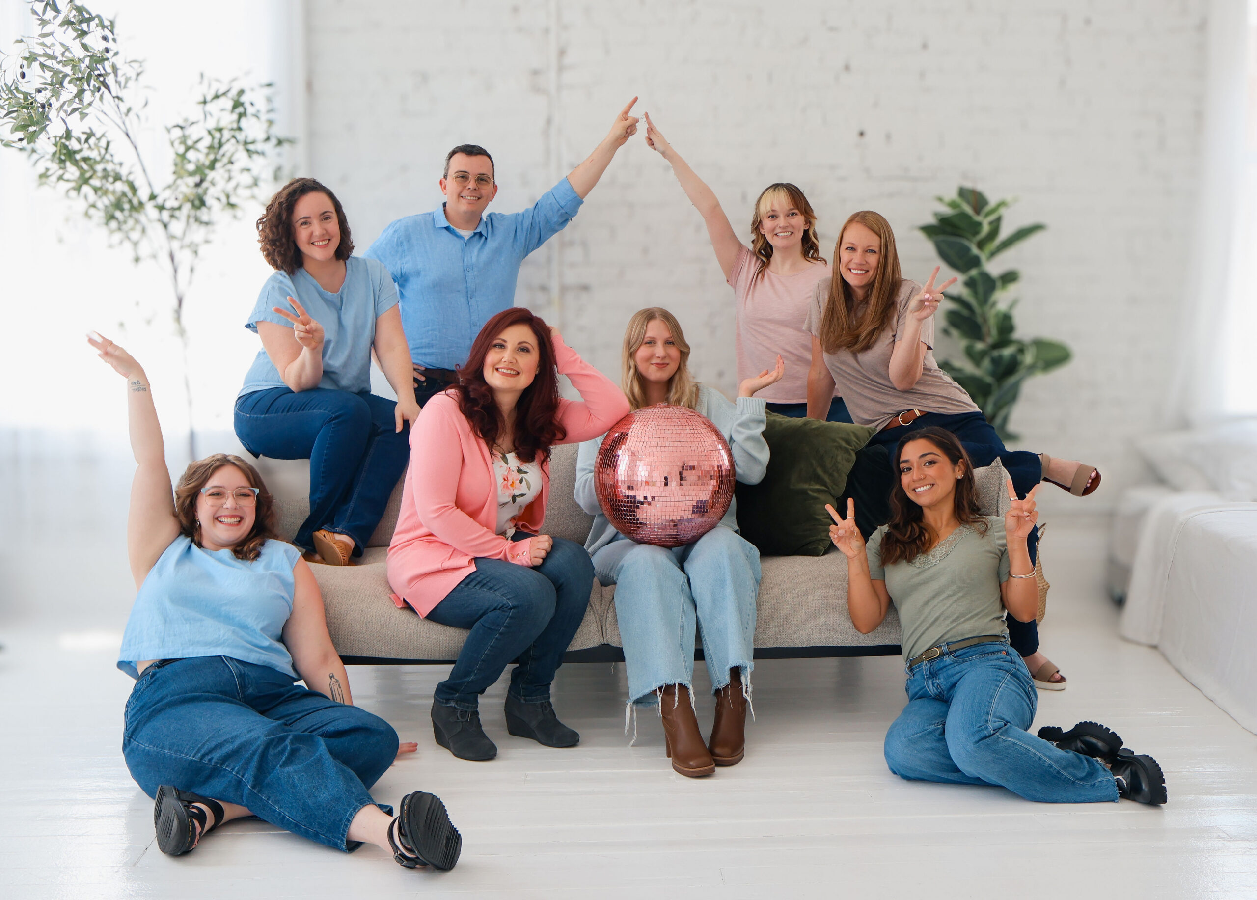 Cincinnati Center for DBT DBT clinicians posing as a group. Three DBT therapists sit on a couch with the one in the middle holding a pink disco ball. Two DBT psychologists sit on the floor. Two DBT counselors sit on the back of the couch. Two DBT counselors stand in the back with arms up and hands touching.