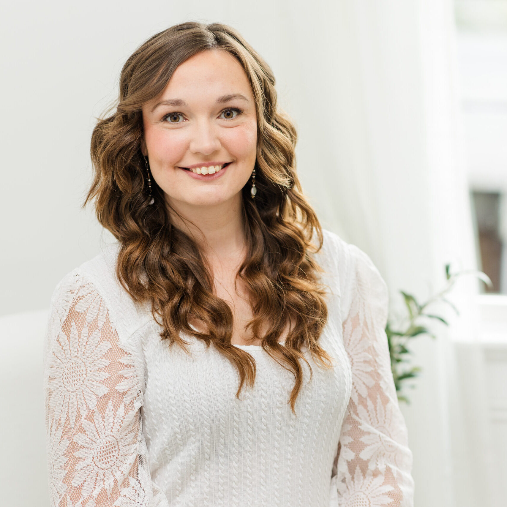 Cincinnati DBT Therapist Melissa Roark sits smiling in white sweater